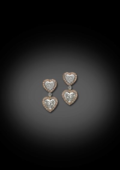 Boucles d'oreilles ‘Toi & Moi’ des cœurs, finis avec un entourage en diamants roses.