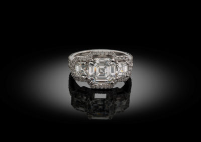 Set of straight cut asscher diamonds, in this white golden trilogy ring.